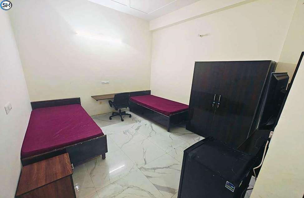 a room with two beds and a cabinet Seventh Heaven PG Gurugram